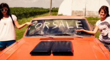 2 Women Selling A Used Car With For Sale Written On Window.